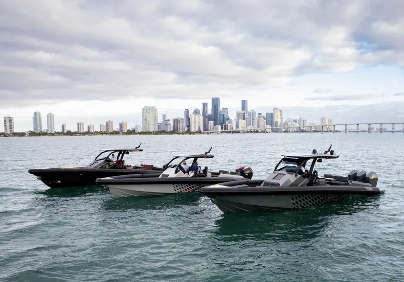 Slide: The Image of Three Skipper-BSK 38 boats on water with city skyline in background, 2024 model. - 14