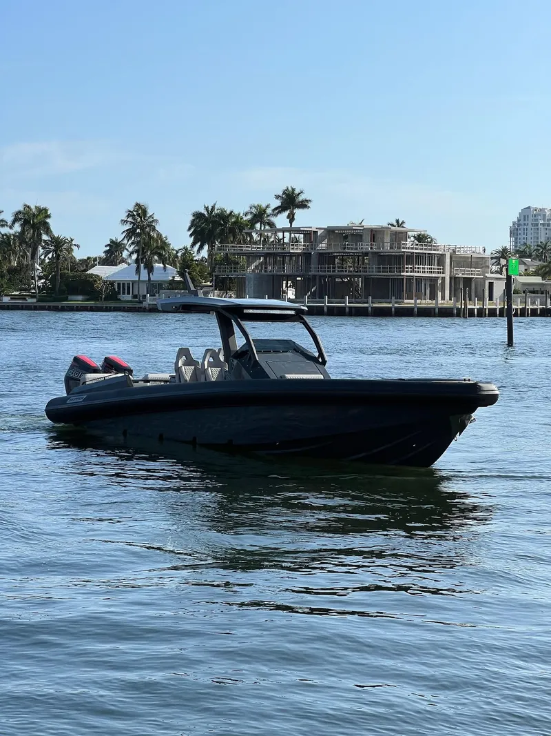 Slide: The Image of 2024 Skipper-BSK 38 boat cruising on a sunny day near waterfront homes. - 5