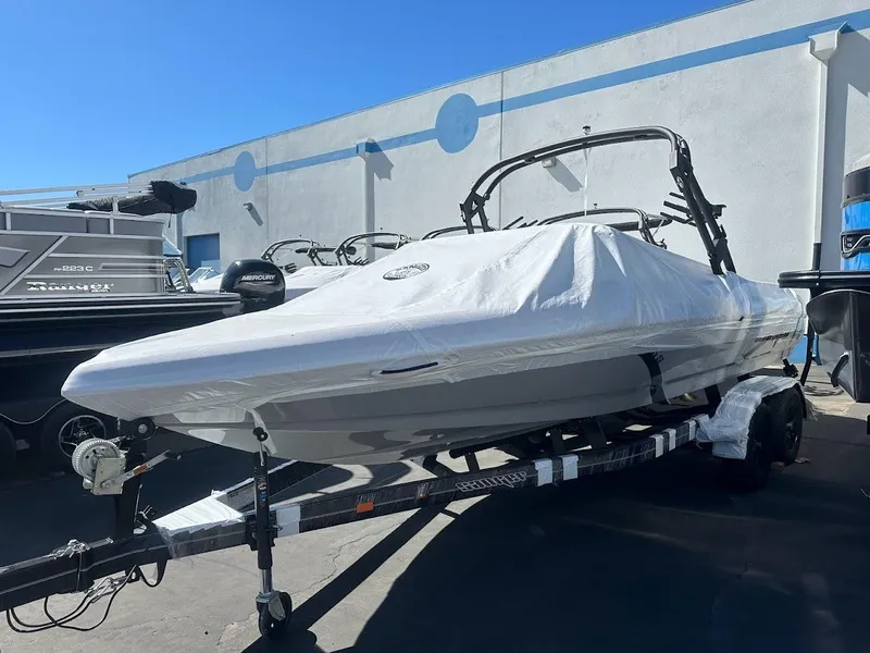 Slide: The Image of 2024 Sanger V215 S boat covered on a trailer in a marina. - 0
