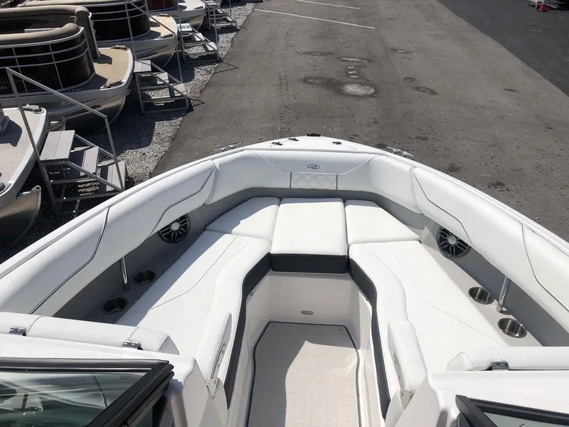 Slide: The Image of 2024 Regal LS4 boat with spacious white seating and cup holders, docked near other boats. - 8