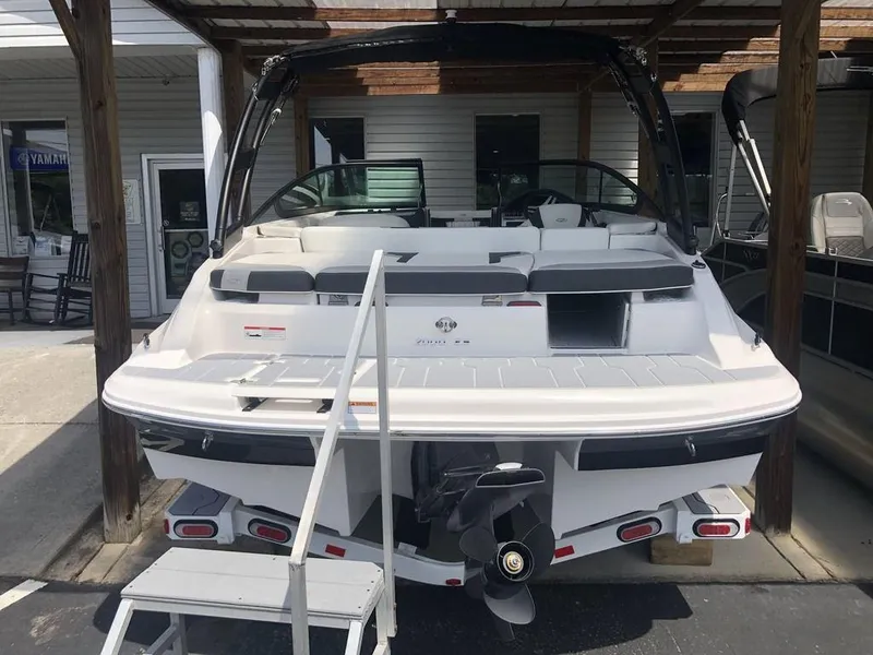 Slide: The Image of 2025 Regal 2000 ES boat, rear view, docked under a wooden canopy. - 7