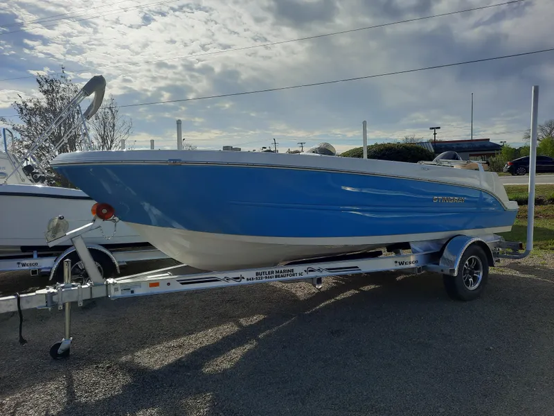 Slide: The Image of 2023 Stingray 172SC boat on a trailer under a partly cloudy sky. - 1