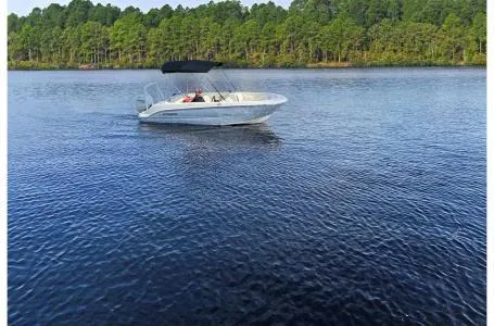 Slide: The Image of 2023 Stingray 172SC boat cruising on a serene lake with a forested shoreline. - 4