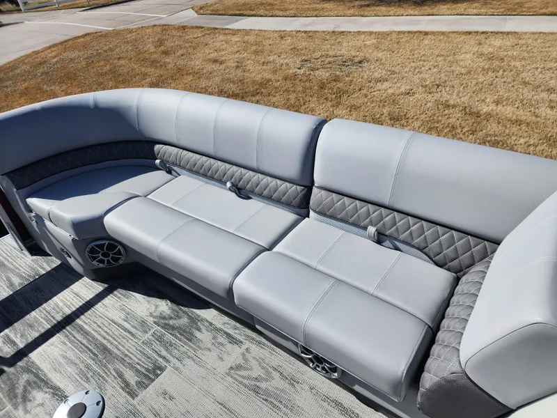 Slide: The Image of 2024 Ranger Reata 220FC boat with luxurious gray seating and built-in speakers. - 10