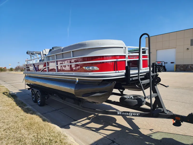 Slide: The Image of 2024 Ranger Reata 220FC pontoon boat on a trailer, red and white exterior. - 2