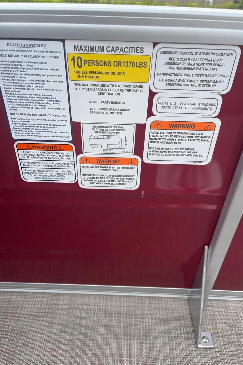 Slide: The Image of 2024 Sun Tracker Party Barge 20 DLX capacity and safety labels on red panel. - 10