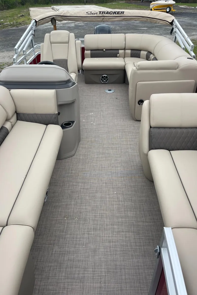 Slide: The Image of 2024 Sun Tracker Party Barge 20 DLX interior with beige seating and spacious layout. - 8
