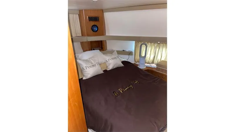 Slide: The Image of 2002 Carver 346 Motor Yacht bedroom with brown bedding and pillows. - 12