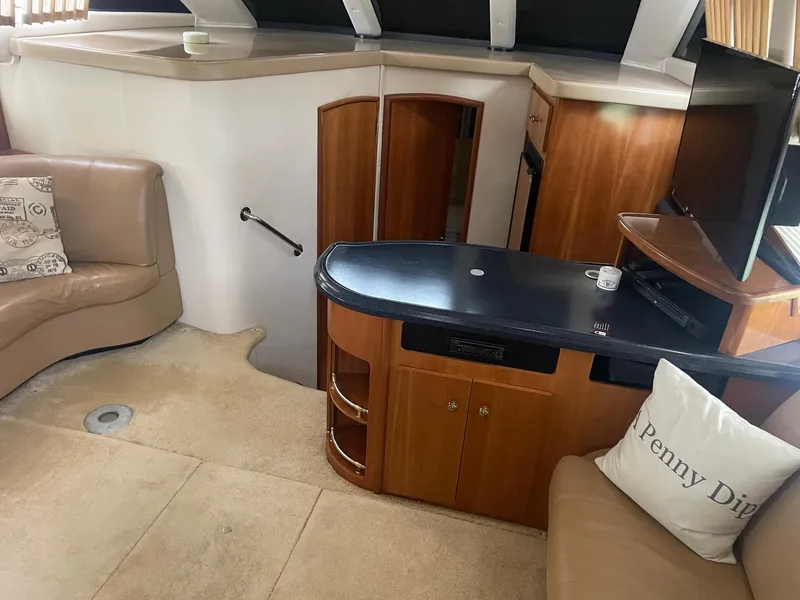 Slide: The Image of Interior of a 2002 Carver 346 Motor Yacht with beige seating and wooden cabinetry. - 16