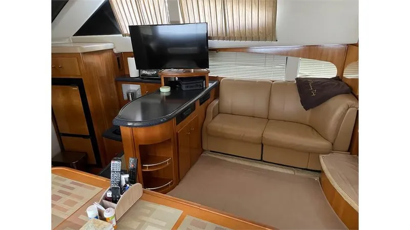 Slide: The Image of Interior of 2002 Carver 346 Motor Yacht with TV, sofa, and wooden cabinetry. - 9