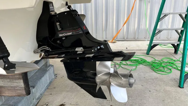 Slide: The Image of MerCruiser outdrive on 2022 Sea Ray SLX 280 boat, with visible propeller and ladder nearby. - 2