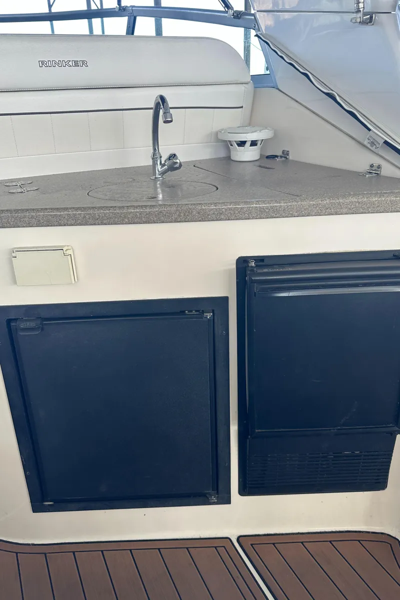 Slide: The Image of 2006 Rinker 360 Express Cruiser kitchenette with sink and storage compartments. - 13