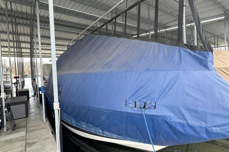 Slide: The Image of 2006 Rinker 360 Express Cruiser covered in blue tarp at marina dock. - 18