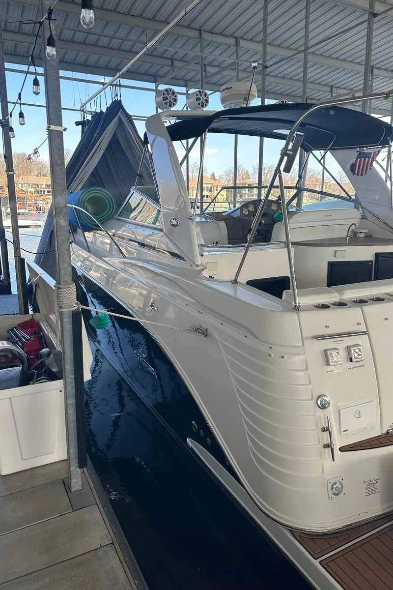 Slide: The Image of 2006 Rinker 360 Express Cruiser docked in a covered marina. - 2