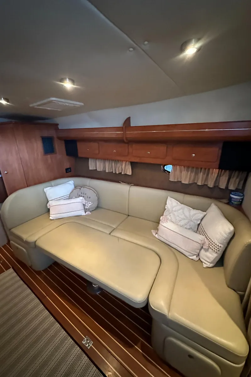 Slide: The Image of 2006 Rinker 360 Express Cruiser interior with beige leather seating and wooden accents. - 20