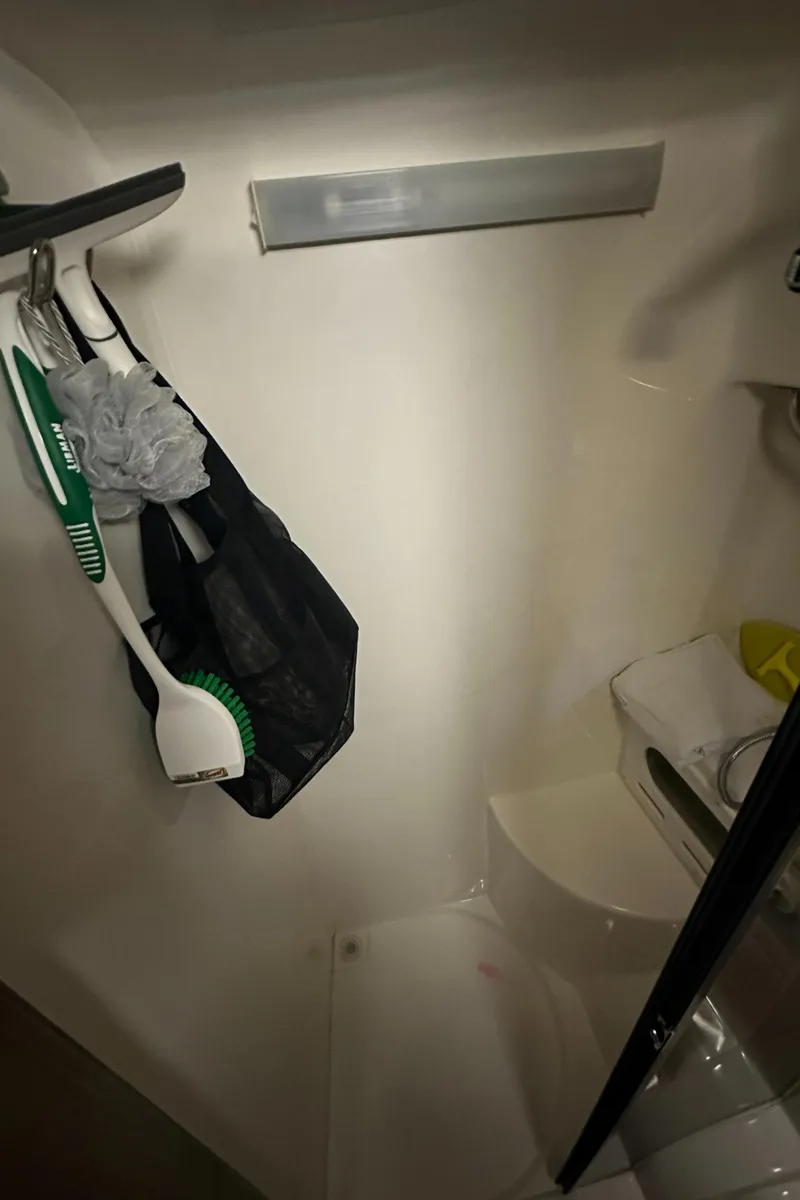 Slide: The Image of Bathroom of a 2006 Rinker 360 Express Cruiser with cleaning supplies. - 27