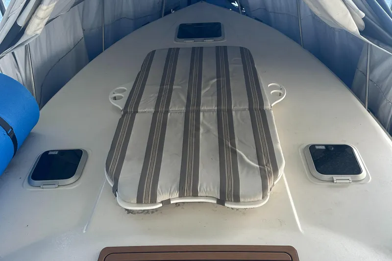 Slide: The Image of 2006 Rinker 360 Express Cruiser bow with striped sun pad and hatches. - 6