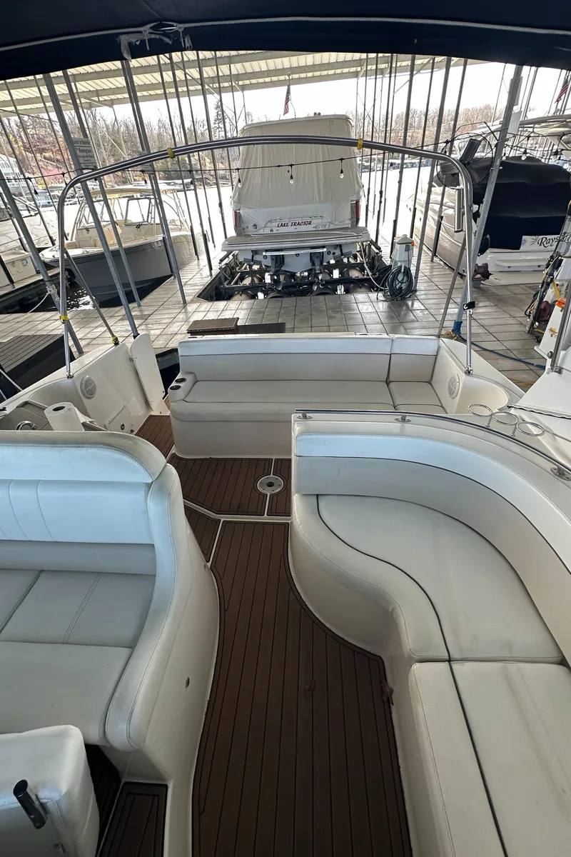 Slide: The Image of 2006 Rinker 360 Express Cruiser with spacious seating and teak flooring in a covered marina. - 8