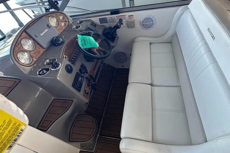 Slide: The Image of 2006 Rinker 360 Express Cruiser helm with white seating and wooden dashboard. - 9