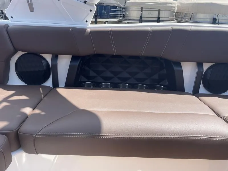 Slide: The Image of 2024 Malibu 21 LX boat interior with brown leather seating and built-in speakers. - 11