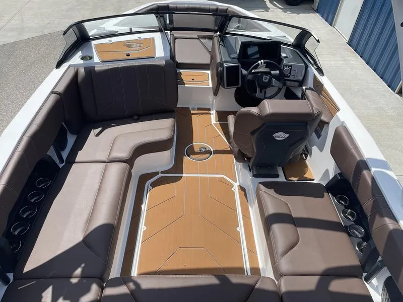Slide: The Image of 2024 Malibu 21 LX boat interior with brown seating and modern dashboard. - 12