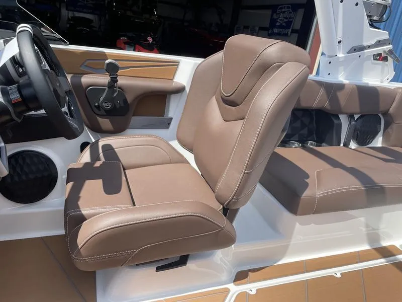 Slide: The Image of 2024 Malibu 21 LX boat interior with brown leather seats and modern dashboard. - 16