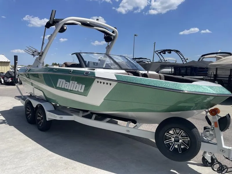 Slide: The Image of 2024 Malibu 21 LX boat on a trailer under a clear blue sky. - 3