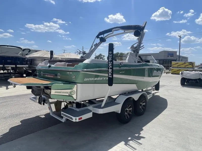 Slide: The Image of 2024 Malibu 21 LX boat on trailer, green and white, sunny day. - 5