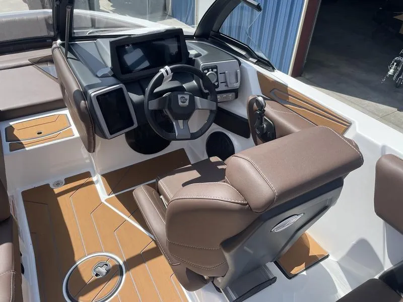 Slide: The Image of 2024 Malibu 21 LX boat interior with modern dashboard and brown seating. - 6