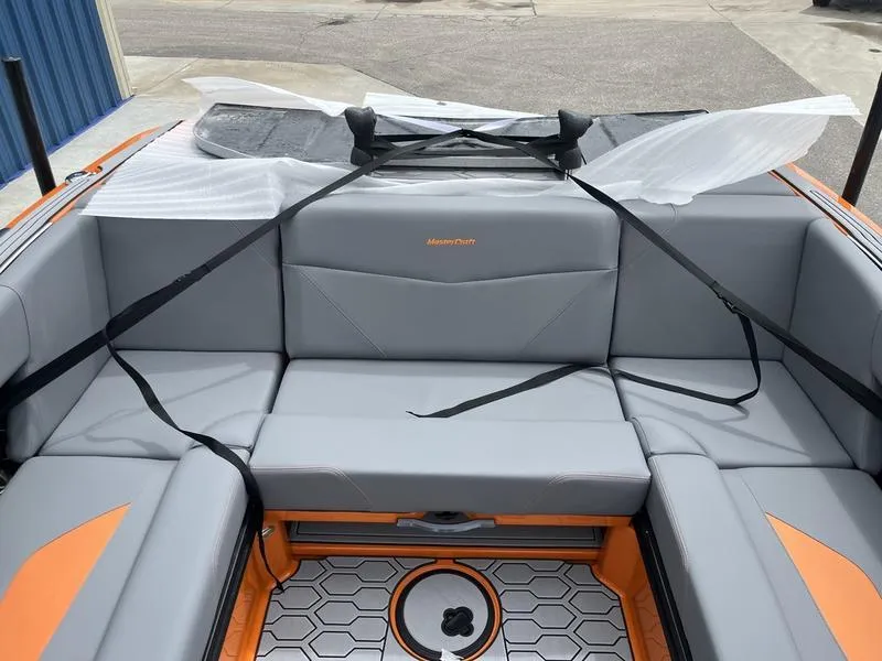 Slide: The Image of 2024 MasterCraft NXT23 boat interior with gray and orange seating. - 7