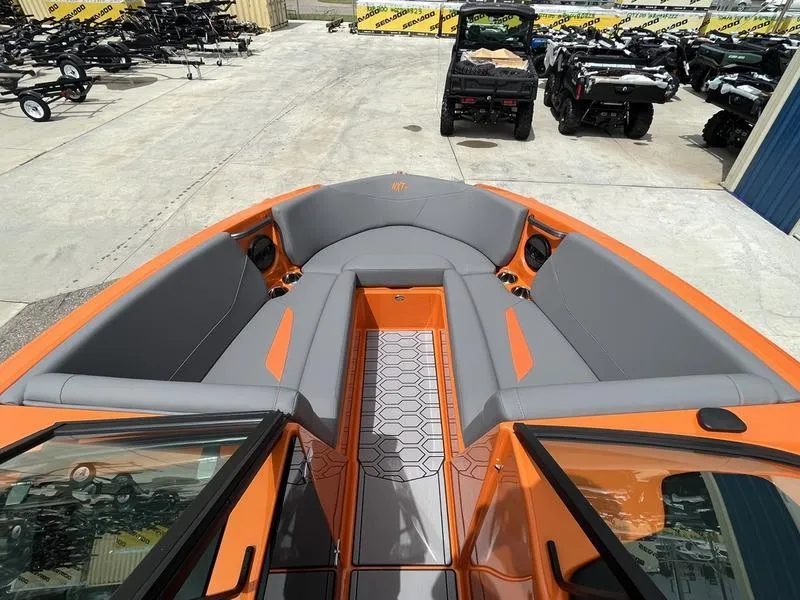 Slide: The Image of 2024 MasterCraft NXT23 boat with orange and gray interior, docked at a marina. - 8