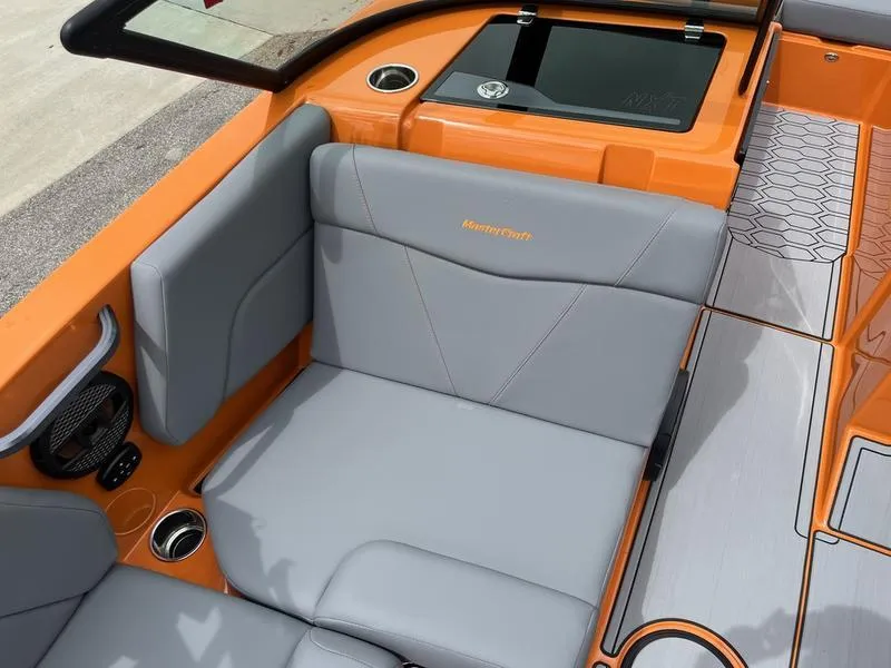 Slide: The Image of 2024 MasterCraft NXT23 boat interior with orange and gray seating. - 9