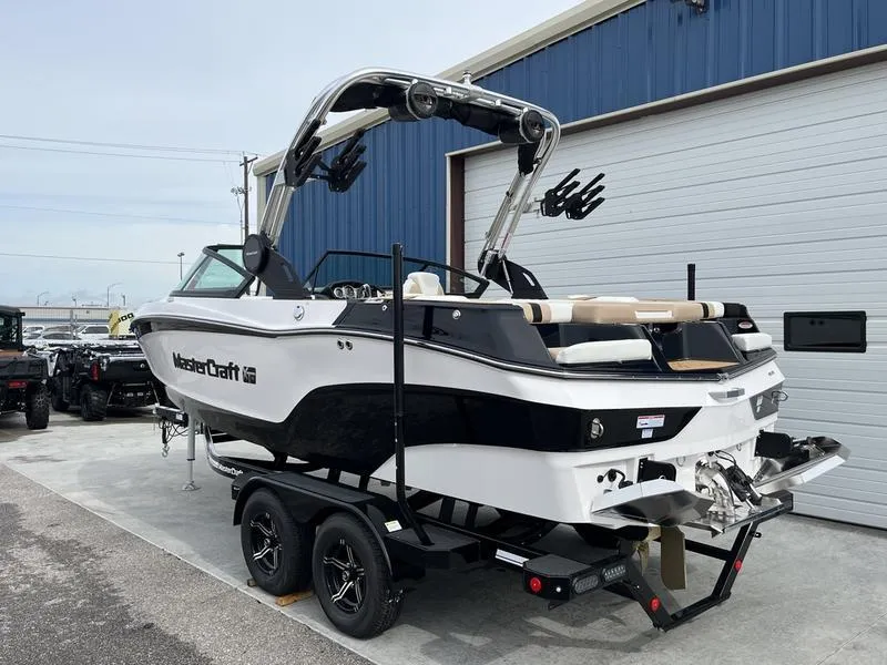 Slide: The Image of 2024 MasterCraft XT20 boat on trailer outside blue building. - 4