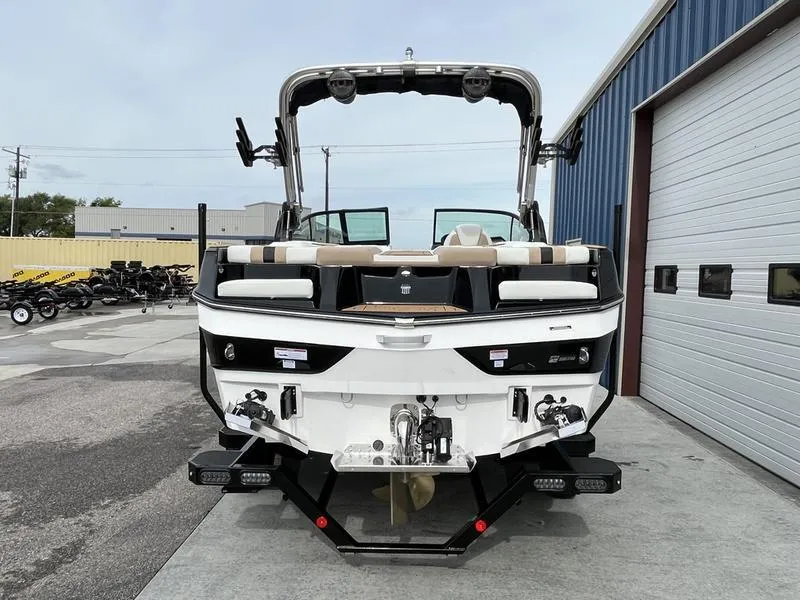 Slide: The Image of 2024 MasterCraft XT20 boat, rear view, parked outside a warehouse. - 8