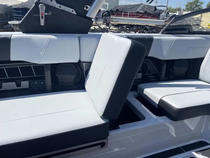 Slide: The Image of 2023 Malibu 24 MXZ boat interior with white and black seating. - 11