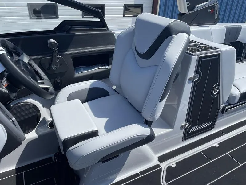 Slide: The Image of 2023 Malibu 24 MXZ boat interior with white and black seating. - 13