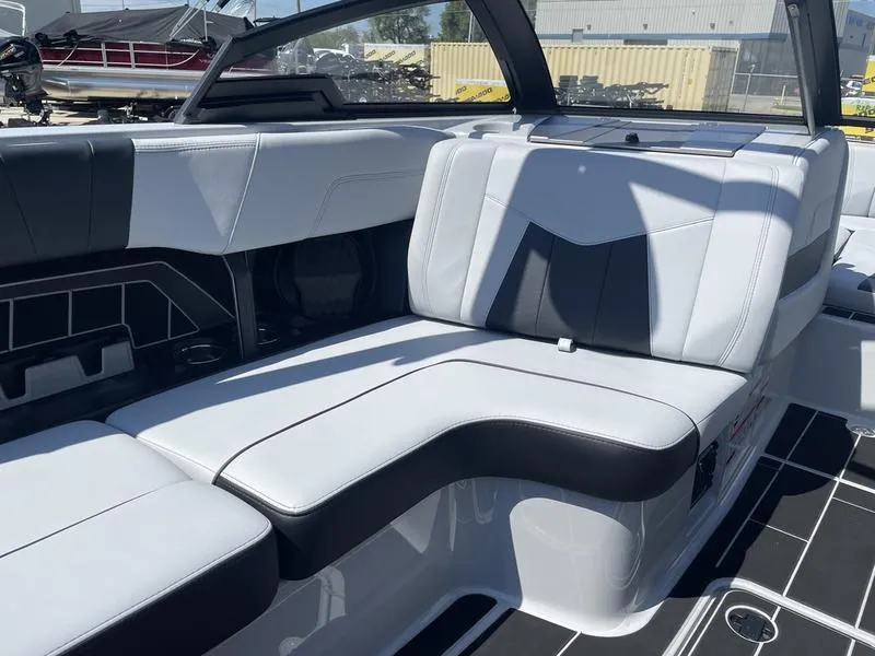 Slide: The Image of 2023 Malibu 24 MXZ boat interior with white and black seating. - 15