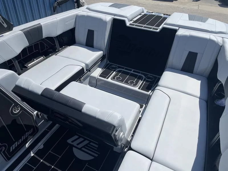 Slide: The Image of 2023 Malibu 24 MXZ boat interior with luxurious seating and cup holders. - 18
