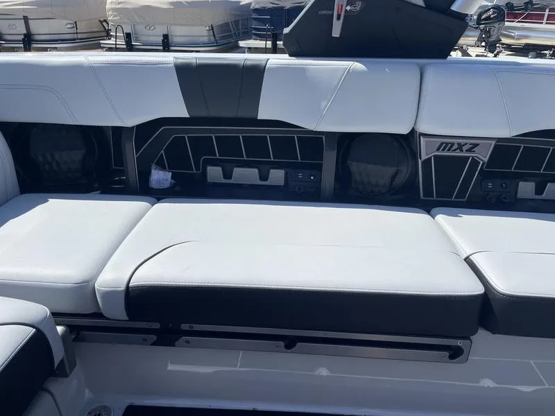 Slide: The Image of 2023 Malibu 24 MXZ boat interior with white and black seating. - 19