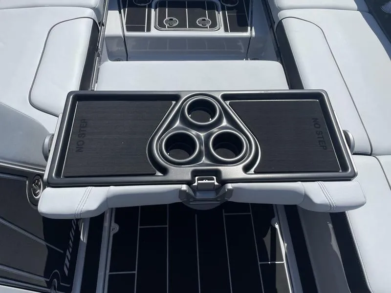 Slide: The Image of 2023 Malibu 24 MXZ boat interior with cup holders and seating area. - 20