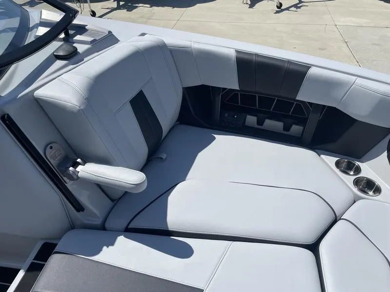 Slide: The Image of 2023 Malibu 24 MXZ boat interior seating with cup holders. - 24