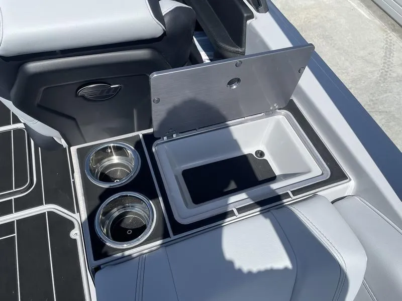 Slide: The Image of 2023 Malibu 24 MXZ boat interior with cup holders and storage compartment. - 25