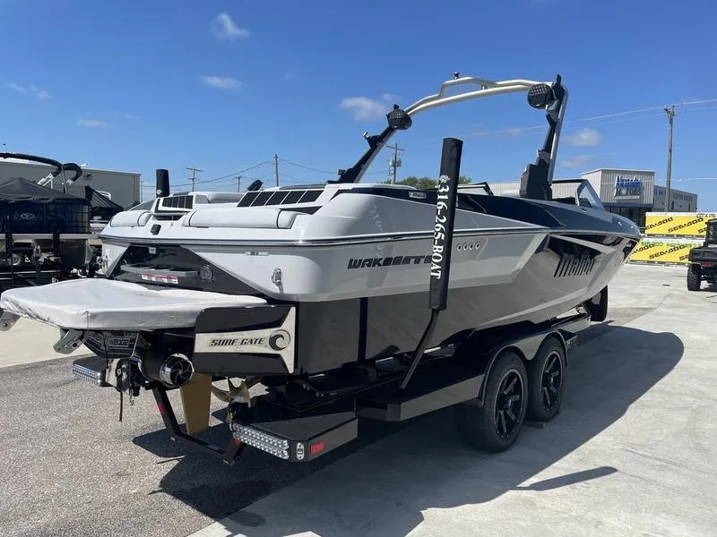 Slide: The Image of 2023 Malibu 24 MXZ wakeboard boat on a trailer in a marina. - 5