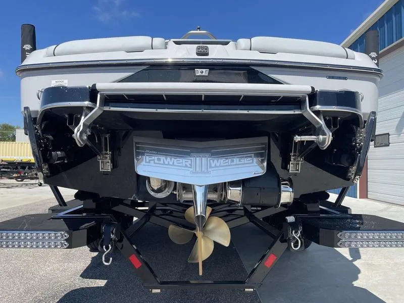 Slide: The Image of 2023 Malibu 24 MXZ boat stern view with propeller and Power Wedge III. - 6