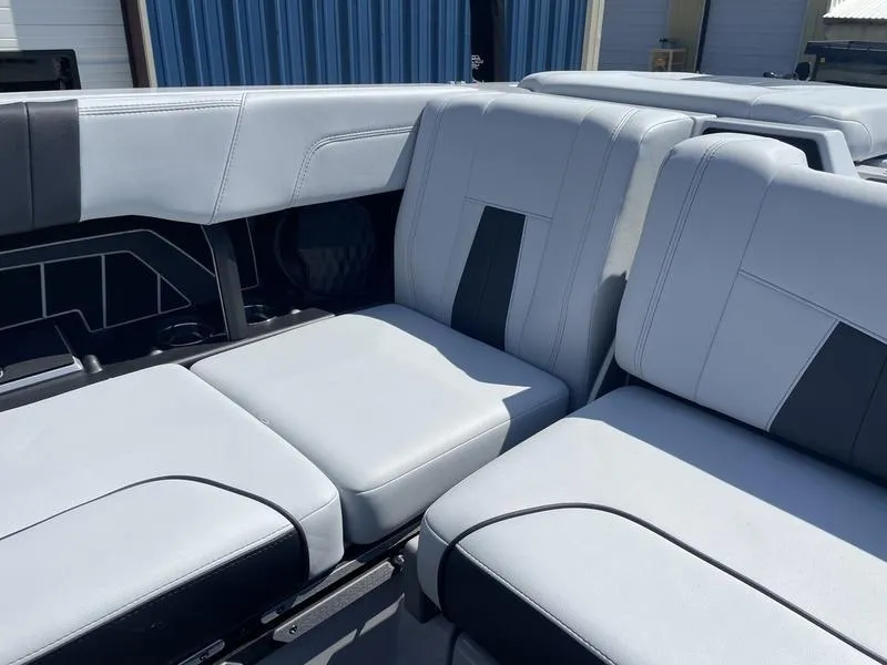 Slide: The Image of 2023 Malibu 24 MXZ boat interior with gray and black seating. - 7