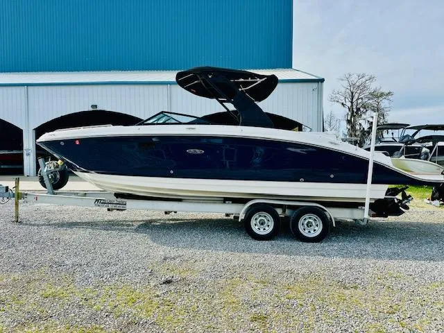 Slide: The Image of 2018 Sea Ray 270 SDX boat on trailer, parked outdoors near a blue building. - 4