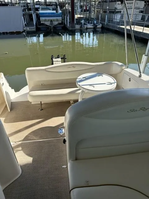Slide: The Image of 2003 Sea Ray 280 Sundancer boat interior with seating and table at marina. - 16