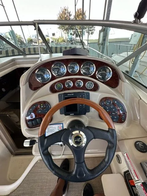 Slide: The Image of 2003 Sea Ray 280 Sundancer helm with gauges and steering wheel. - 17