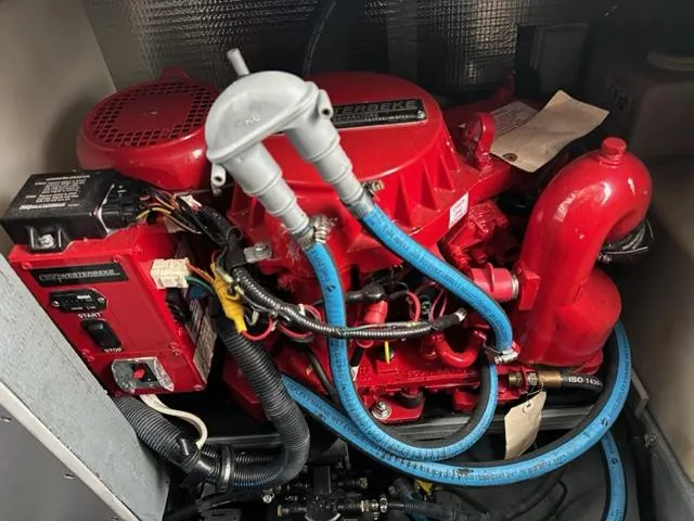 Slide: The Image of 2003 Sea Ray 280 Sundancer engine compartment with red engine and blue hoses. - 19