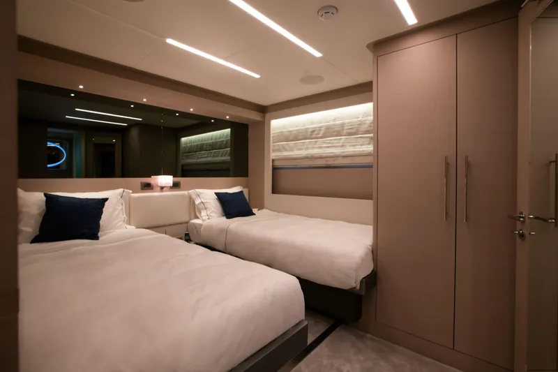 Slide: The Image of Luxurious twin bedroom in 2025 Nomad 95 SUV yacht, featuring modern design and ambient lighting. - 11
